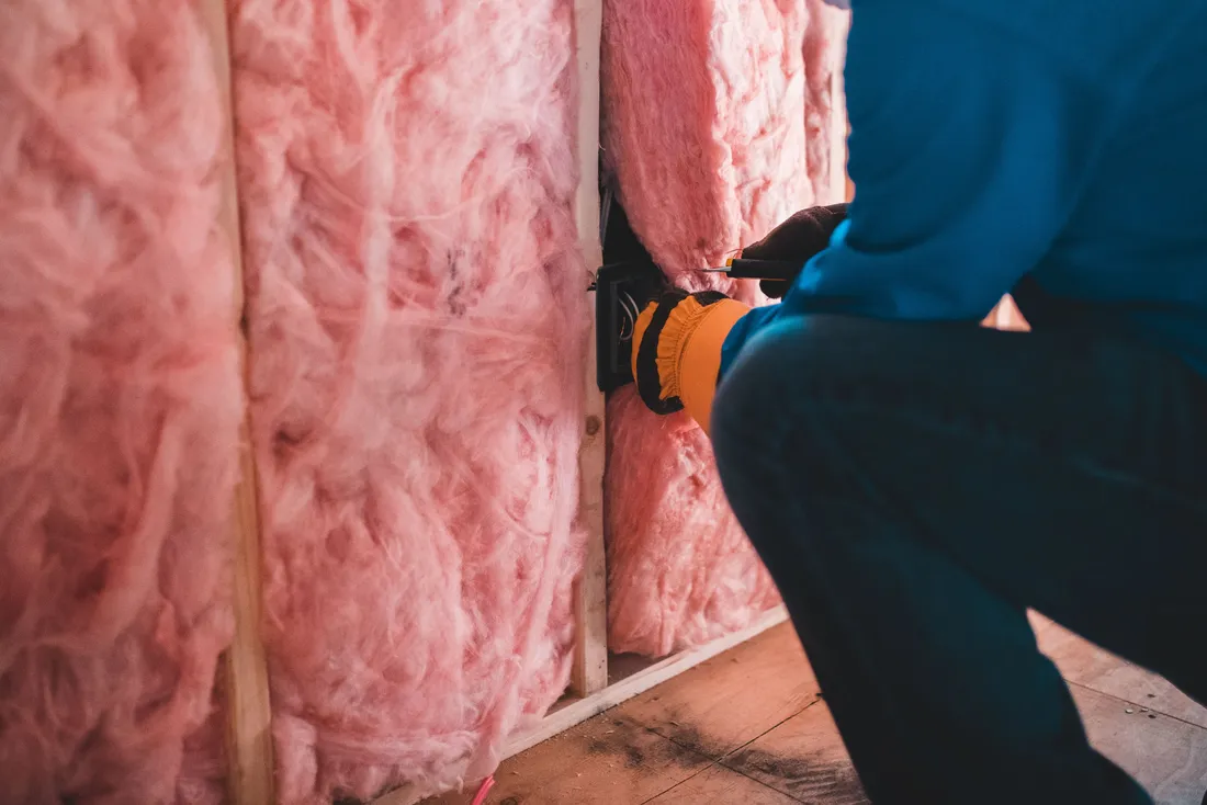 Pose de rouleaux de laine minérale entre les montants (Saint-Étienne-du-Rouvray, Seine-Maritime)